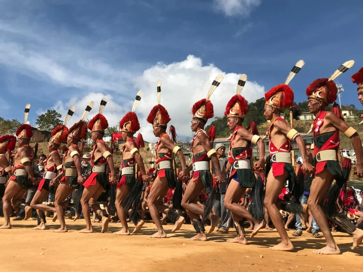 a group of men in colorful uniforms dancing with sticks