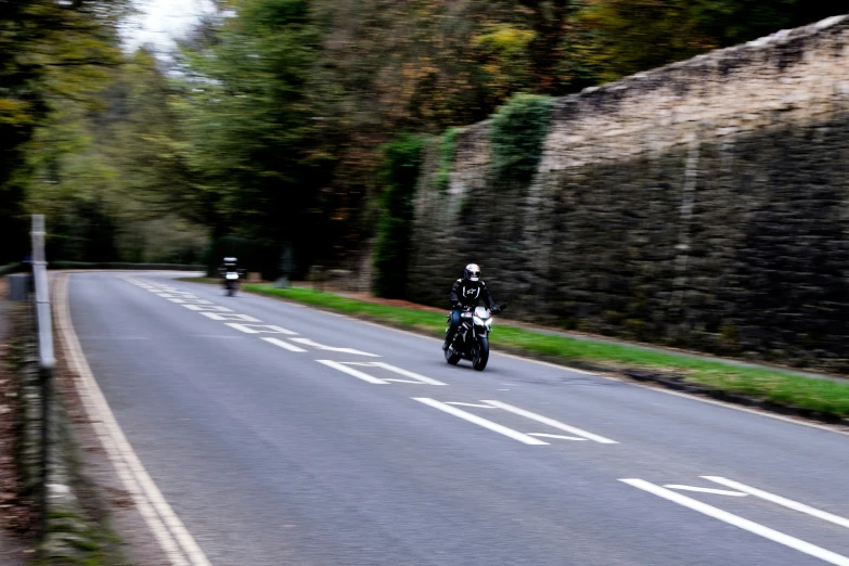 two people riding motorcycles on a country road