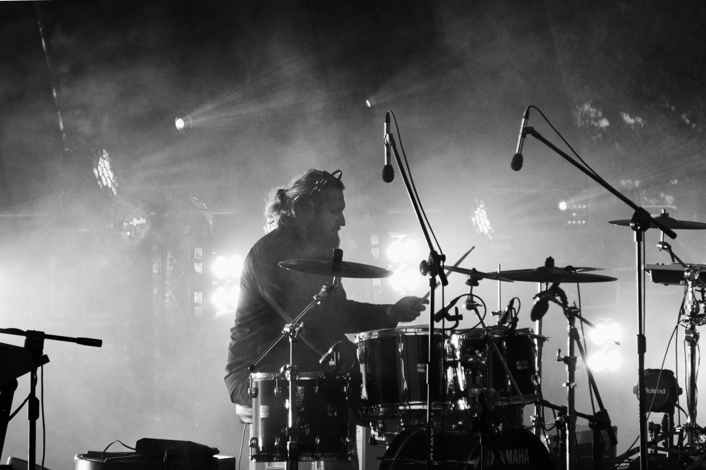 drummers, drums, and drumsticks in a dark room