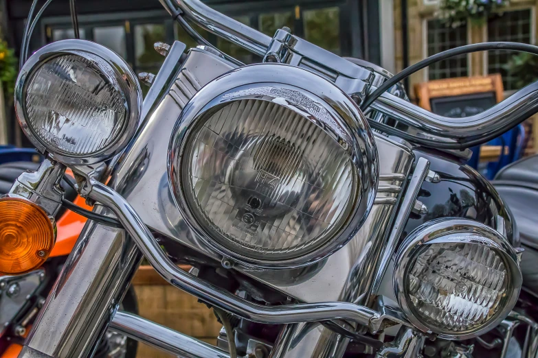 a close up of a motorcycle headlights on an orange and black motorcycle