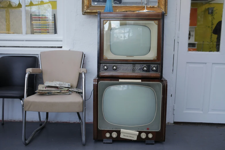 two old televisions in side by side on display