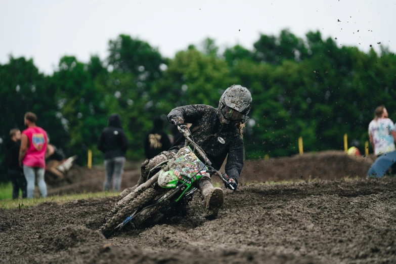 there is a dirt bike rider riding on the muddy hill