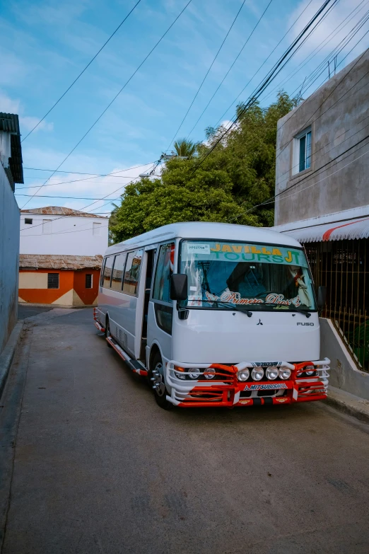 the white bus is stopped on the street