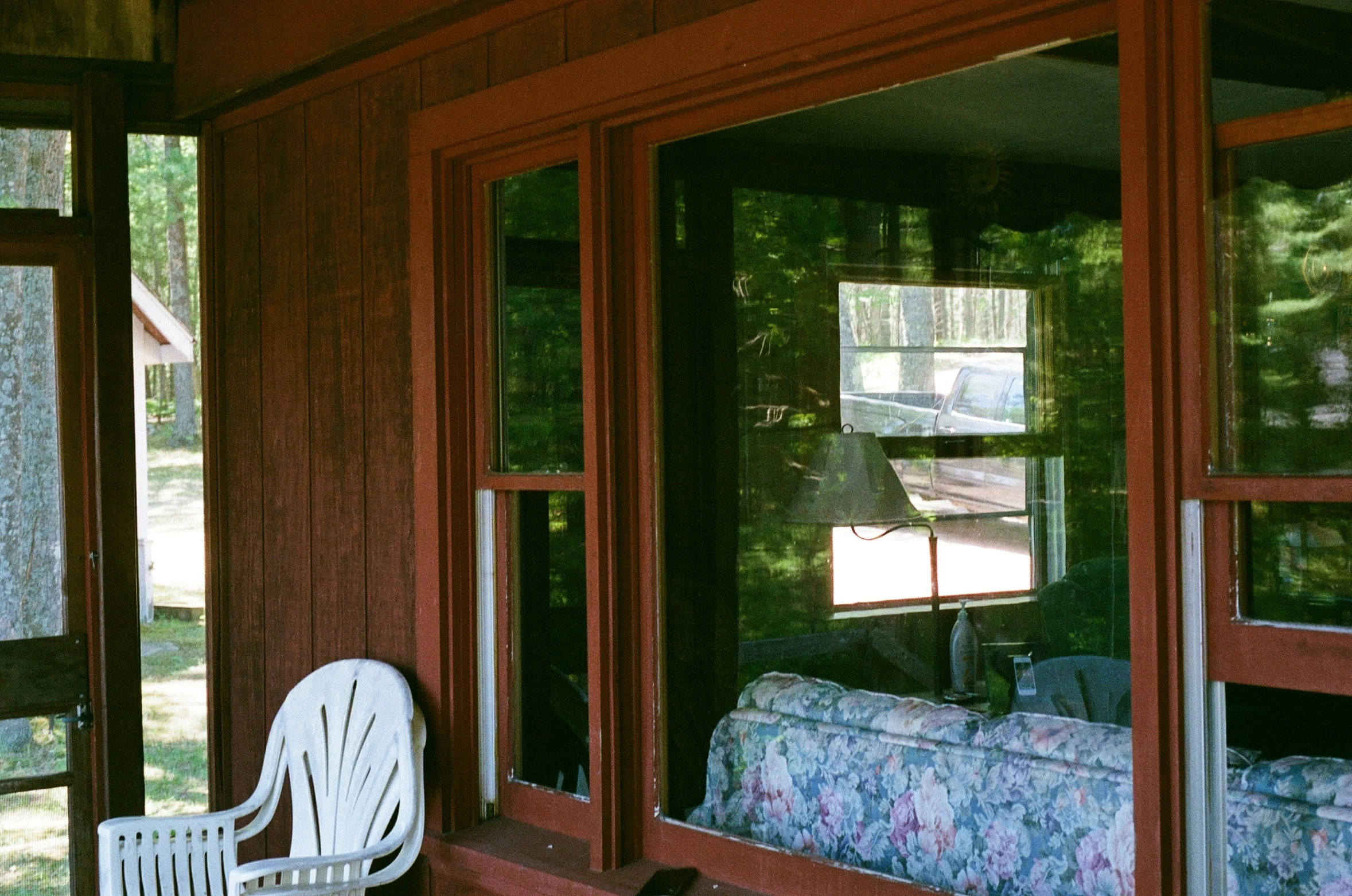 there are white chairs sitting on a porch outside