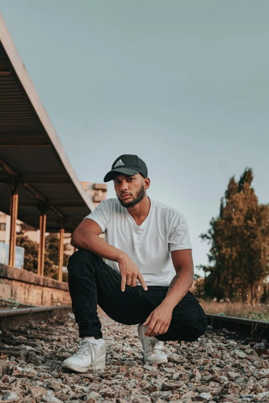 a man kneeling on the train track beside a building