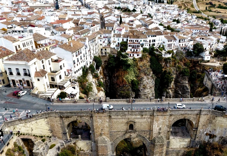 a stone arch bridge spanning the middle of a town