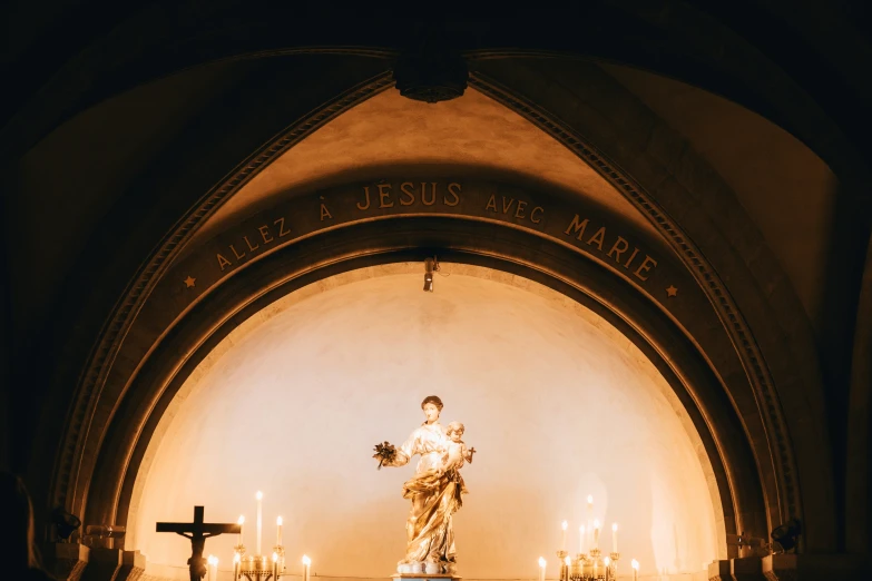 a statue is seen in front of candles and crosses