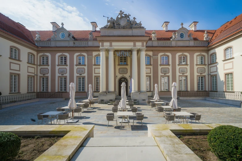 an ornate building features several lawn and seating areas