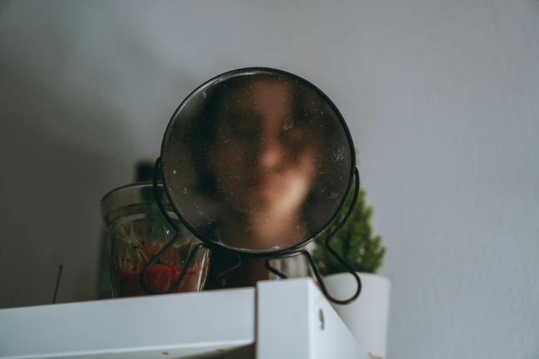 someone's reflection from a magnifying glass