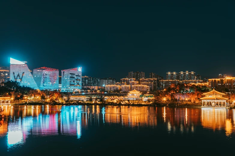 a city lit up with light and reflected in the water