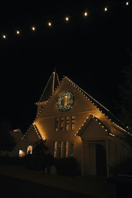 a house lit up with christmas lights and a large clock