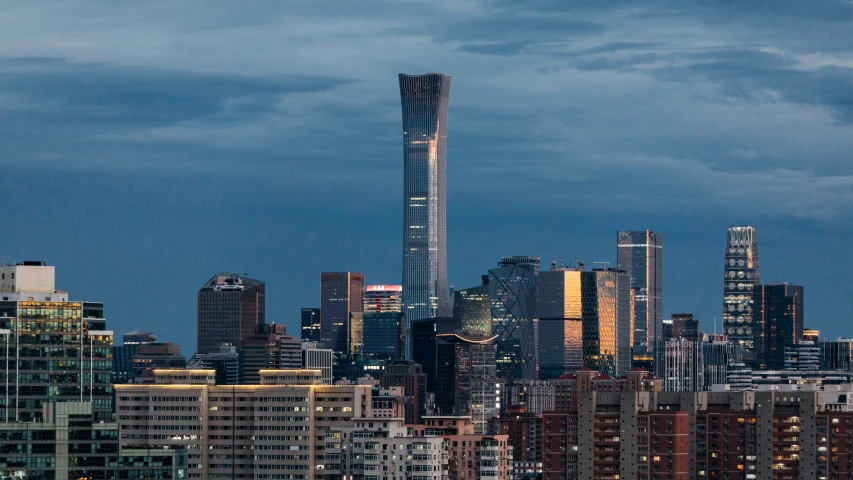 a very tall city skyline with a bright light at night