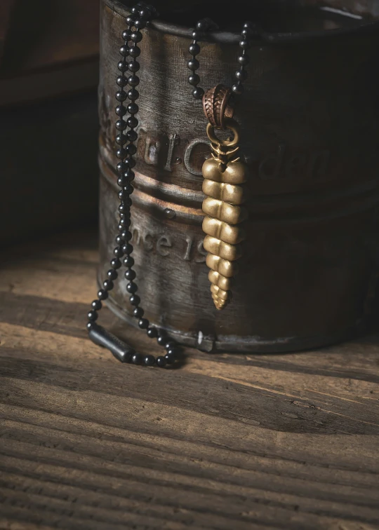 a wooden barrel on a wood surface and some beads are in the foreground