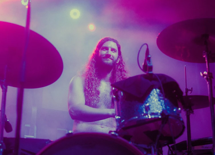 a man that is standing in front of drums