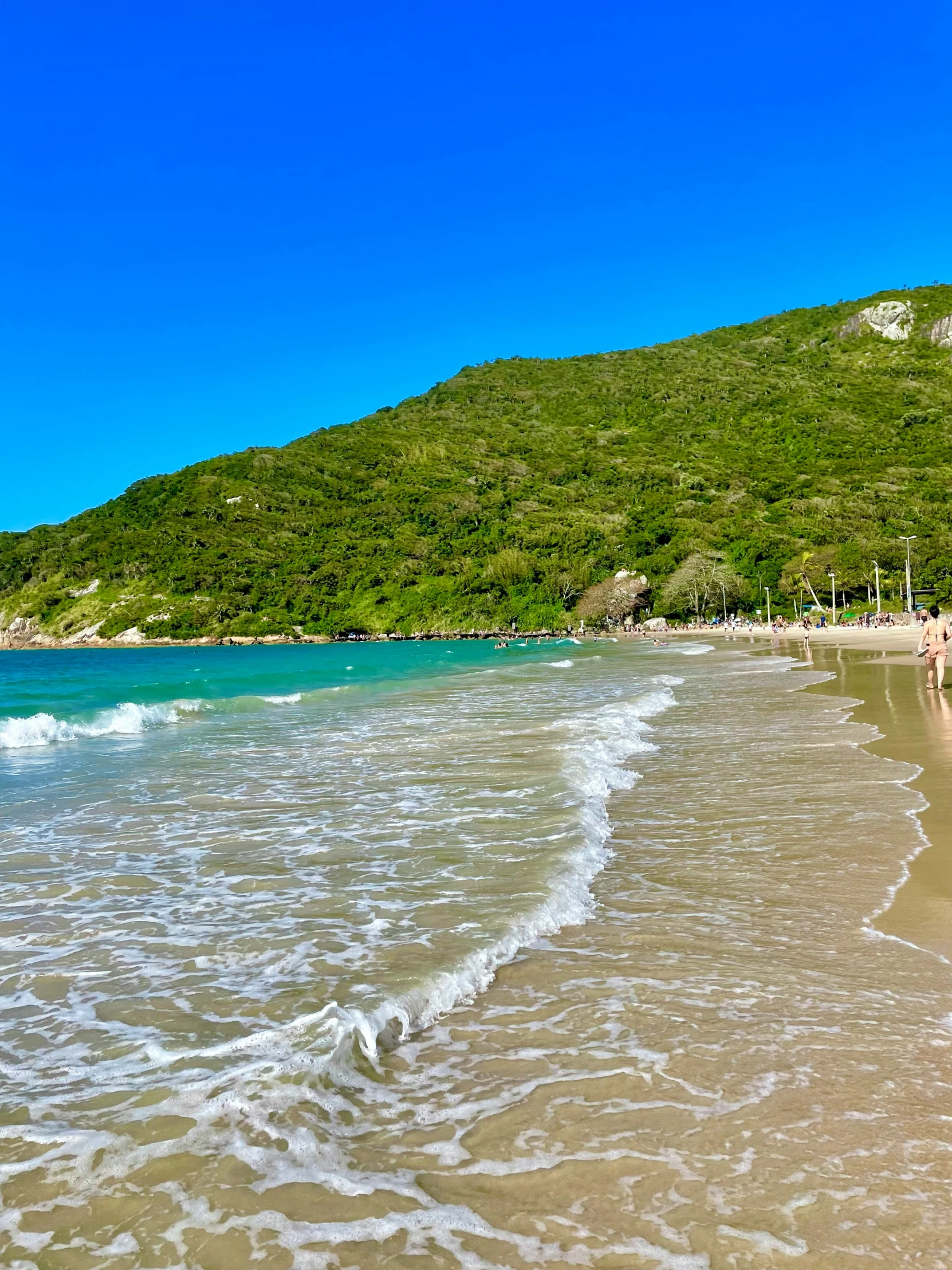 a view of the beach with people walking on the sand