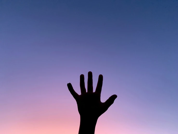 two people's hands are silhouetted against a sunset