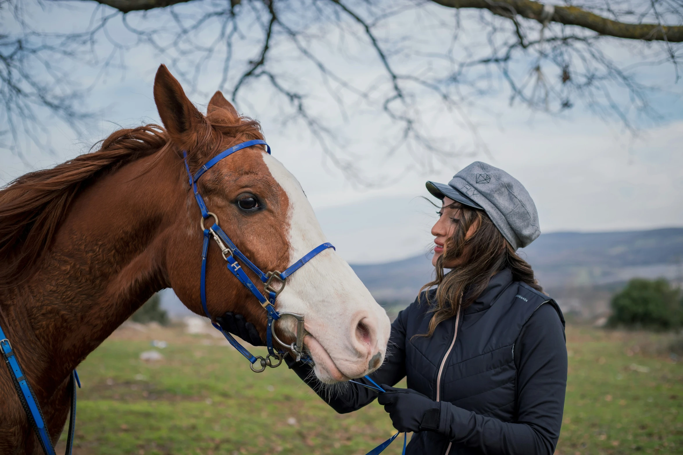 a woman smiles as she touches her horse