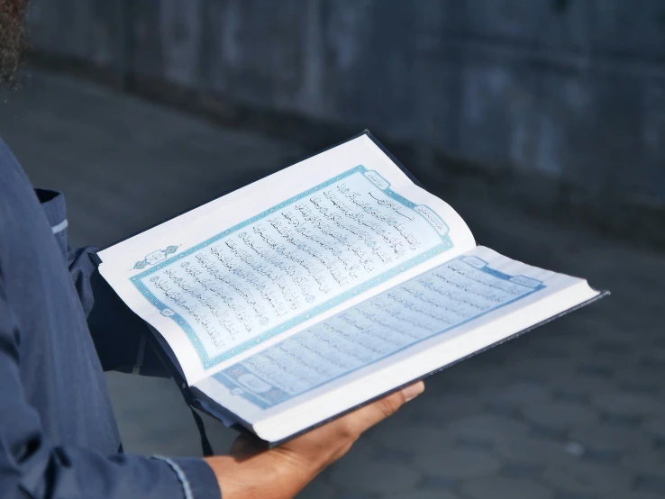 a close up of a persons hands holding an open book