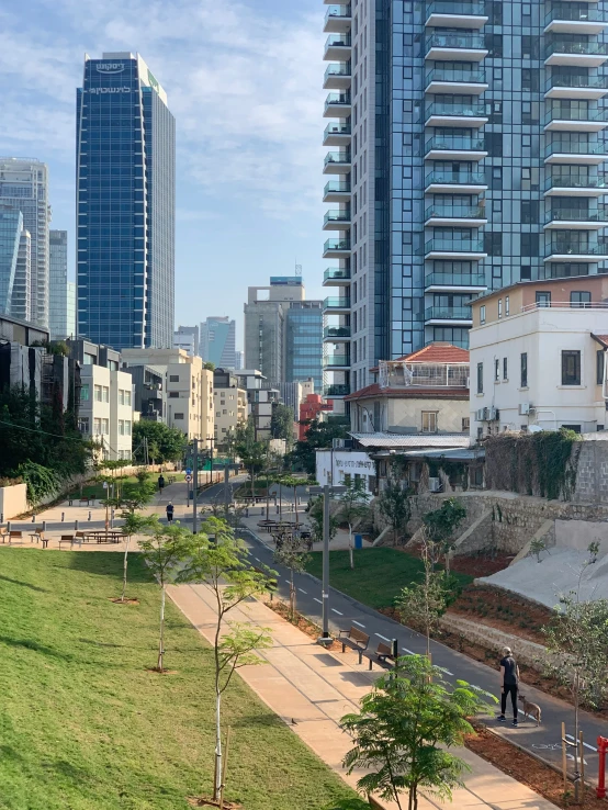 a city park in the middle of two rows of tall buildings