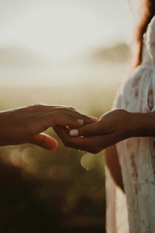 two people standing close together with their hands touching each other