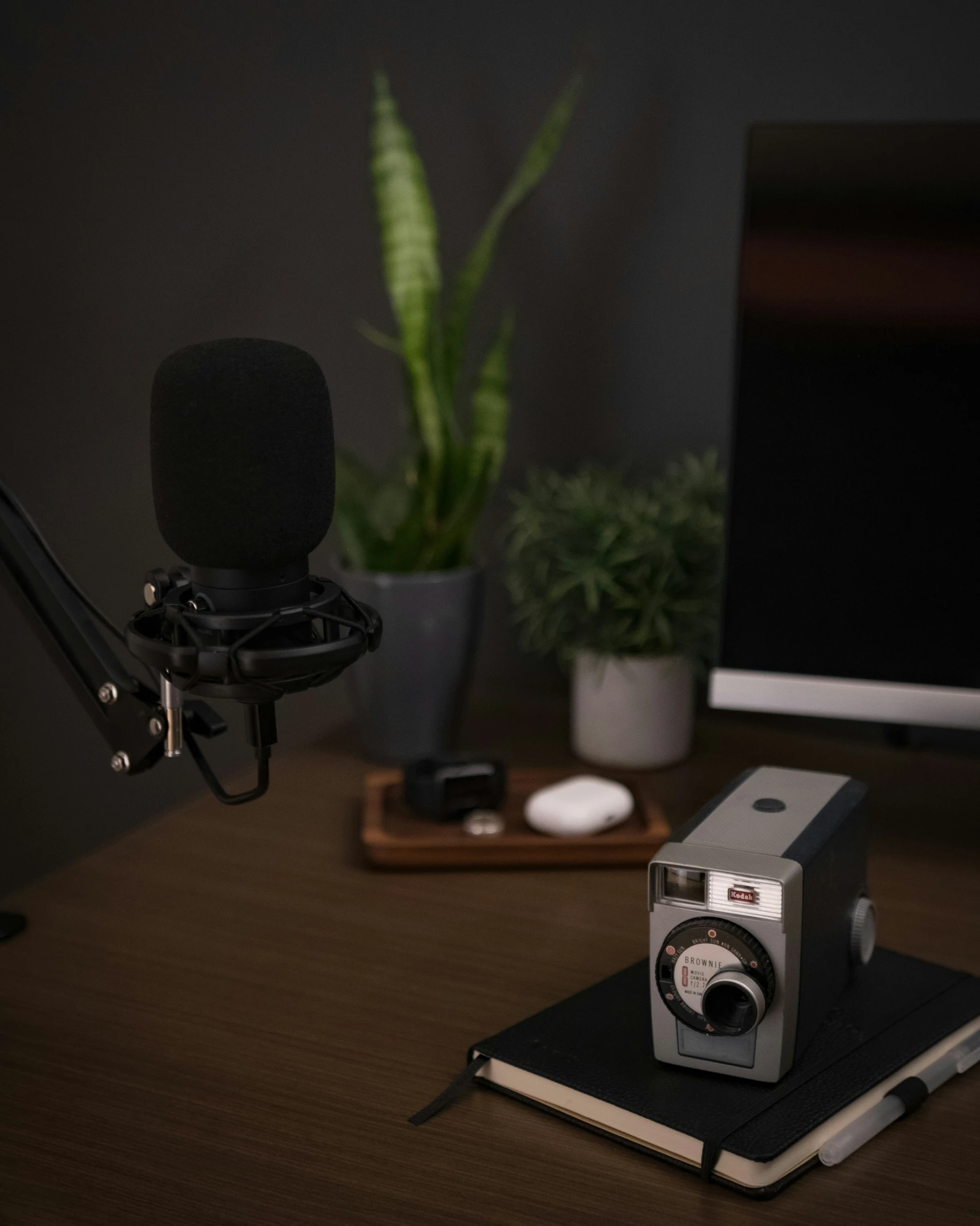 a camera, microphone and notebook on a desk