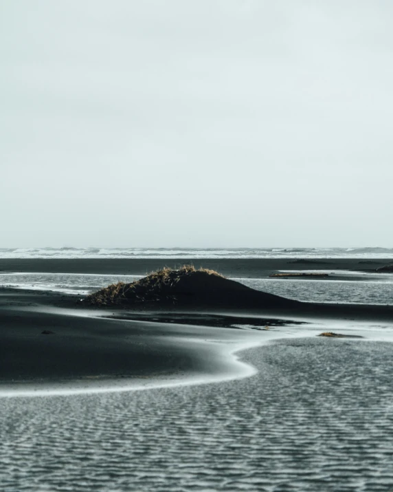 small island in the distance on beach with clouds