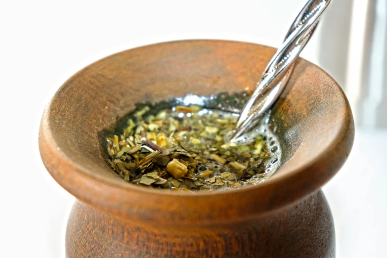 a brown bowl with a silver fork in it and a yellow cup with tea