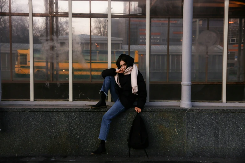 a woman sitting on a window sill with a bag