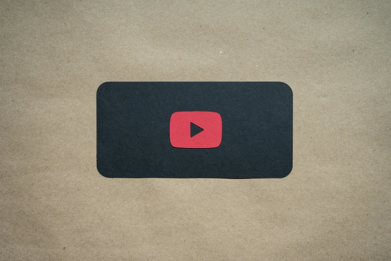 a red and black square shaped mouse pad with an image of a youtube