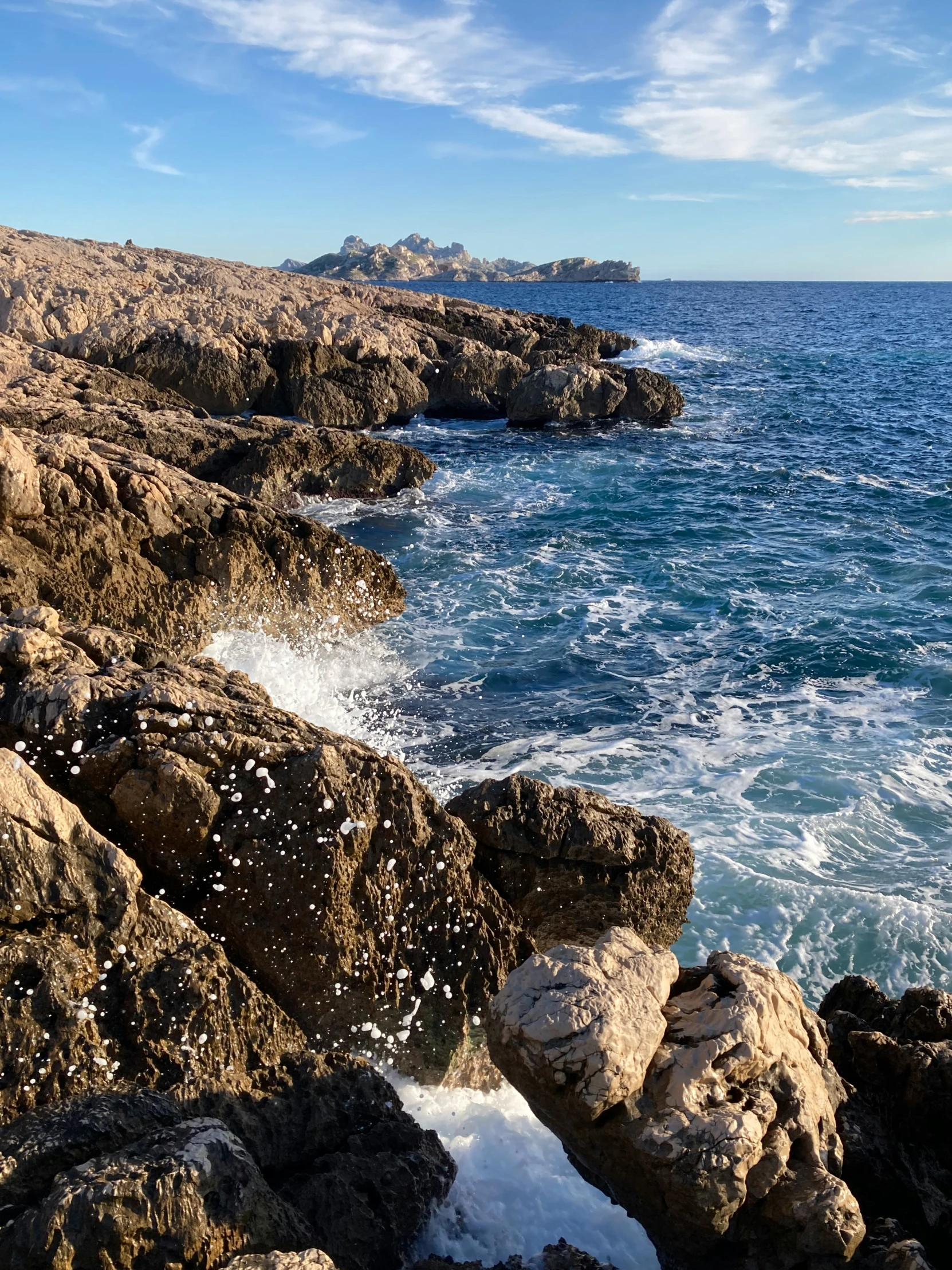 the water is going up to the shore, and rocks have a lot of rocks in it