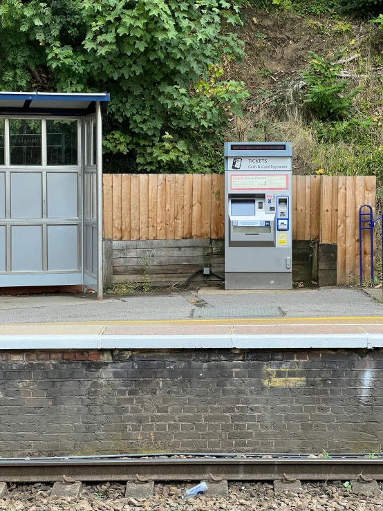 a bank box next to a road with a car parking meter