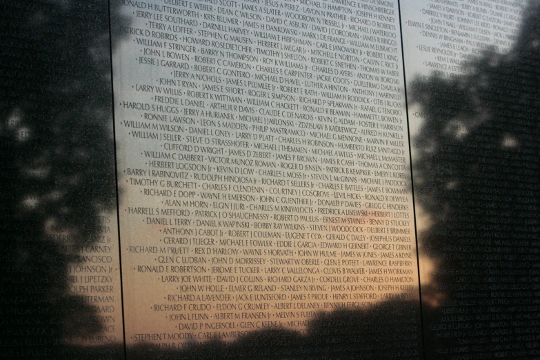 a sunlit memorial with the names of all people murdered