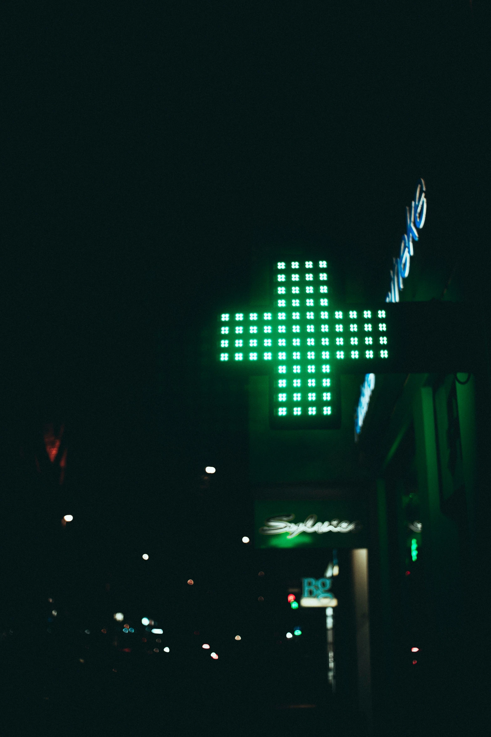 a green street sign illuminated in the night sky