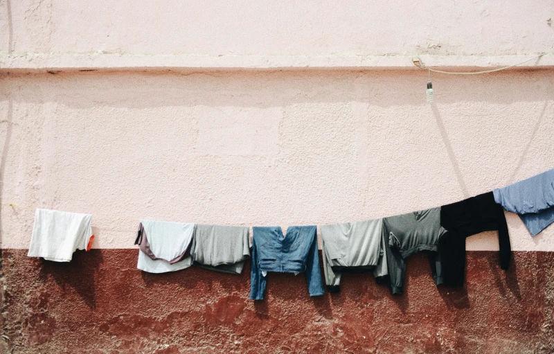 a clothes line on a sidewalk outside of a house