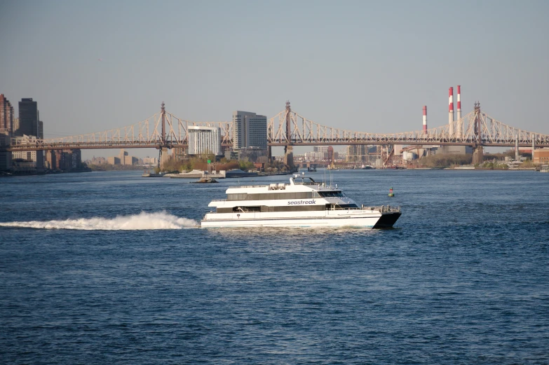 a ferry is traveling by the bay bridge