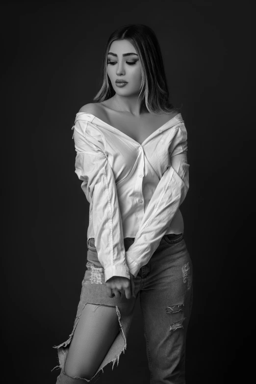 woman in a shirt posing with ripped jeans
