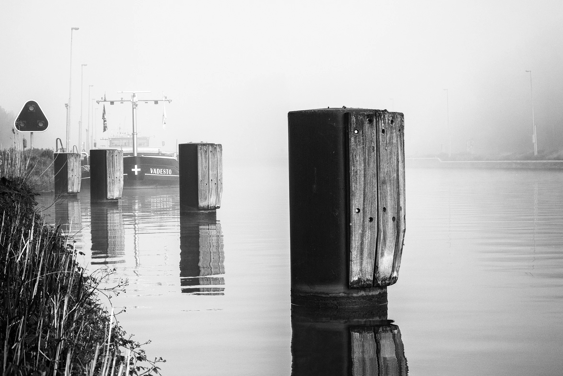 a black and white pograph of water and a pier