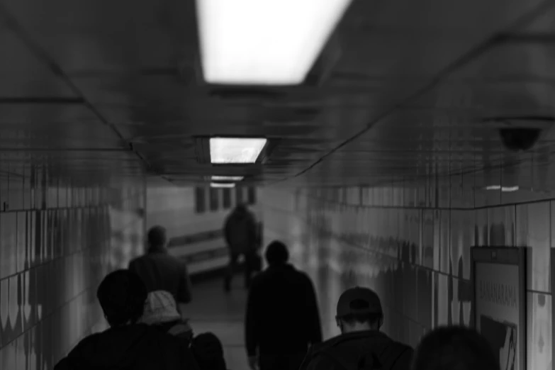 a group of people walking up an empty hallway