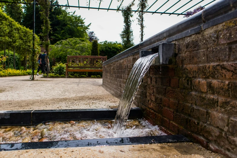 there is water coming from the top of a pipe in the courtyard