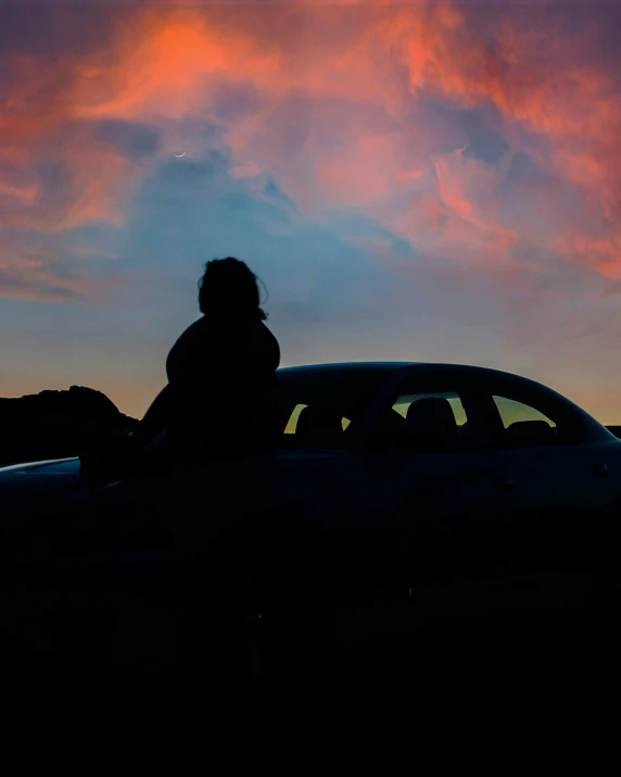 the silhouette of a woman standing next to a car