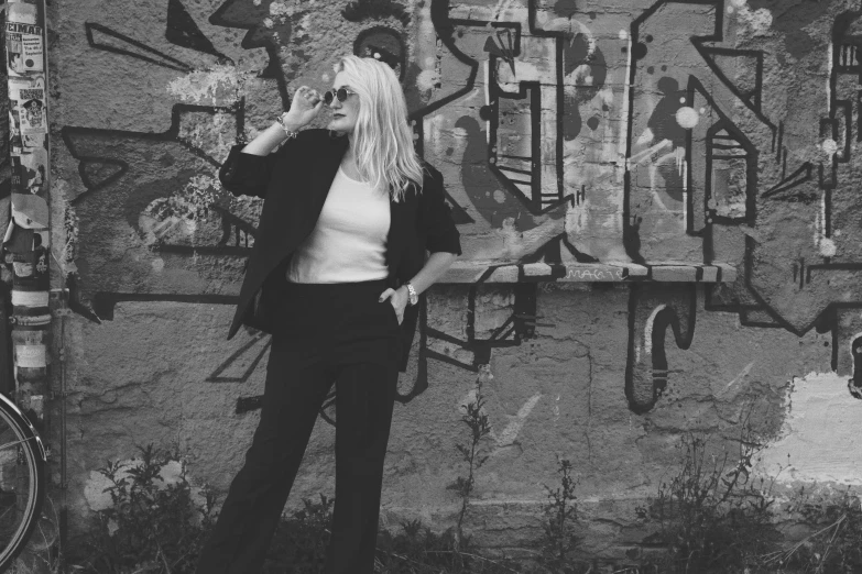 a person standing in front of a wall covered with graffiti