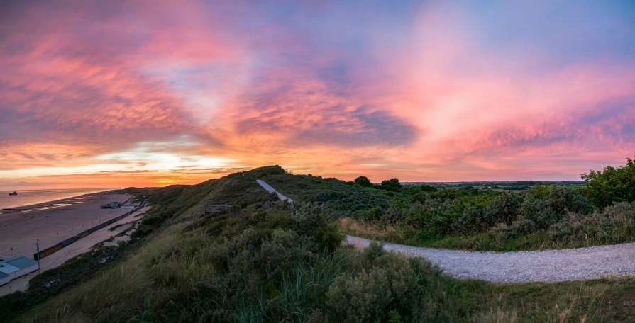 the clouds are changing color at sunset over the beach