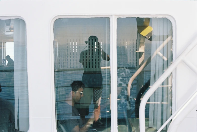 a close up of two people on a boat looking through the window