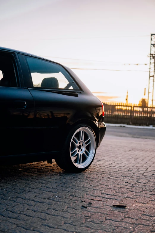 a black car on brick ground near water