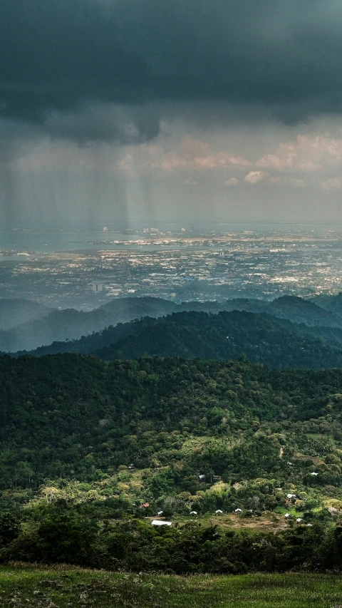 a lush green hillside under storm clouds