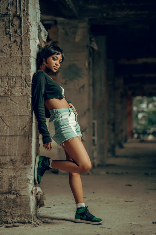 a woman posing for a po leaning against the side of a wall