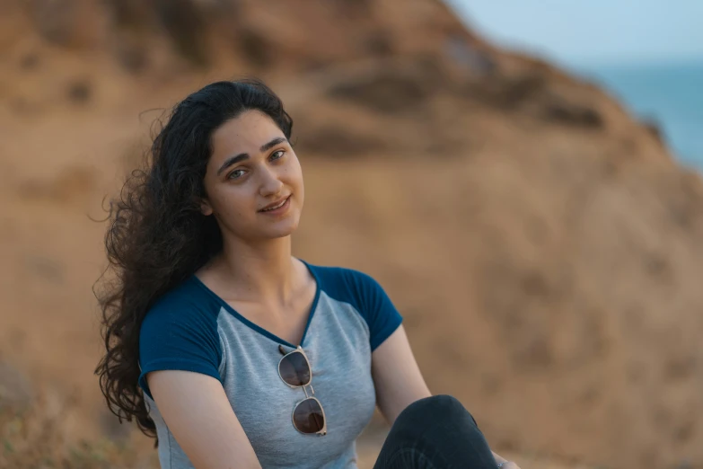 a woman sitting on the edge of a cliff