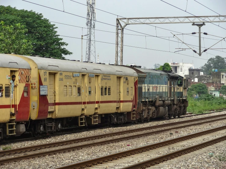 an old yellow train is passing by some train tracks