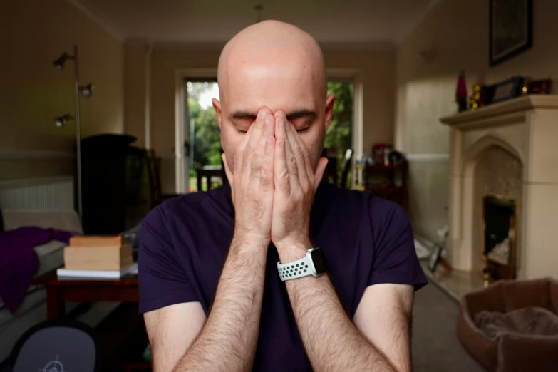 a man is covering his face with hands