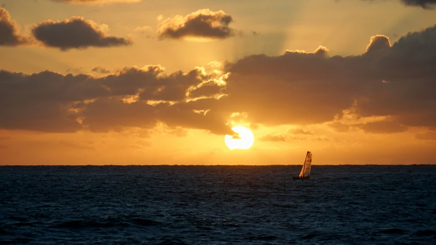 two boats in the ocean at sunset